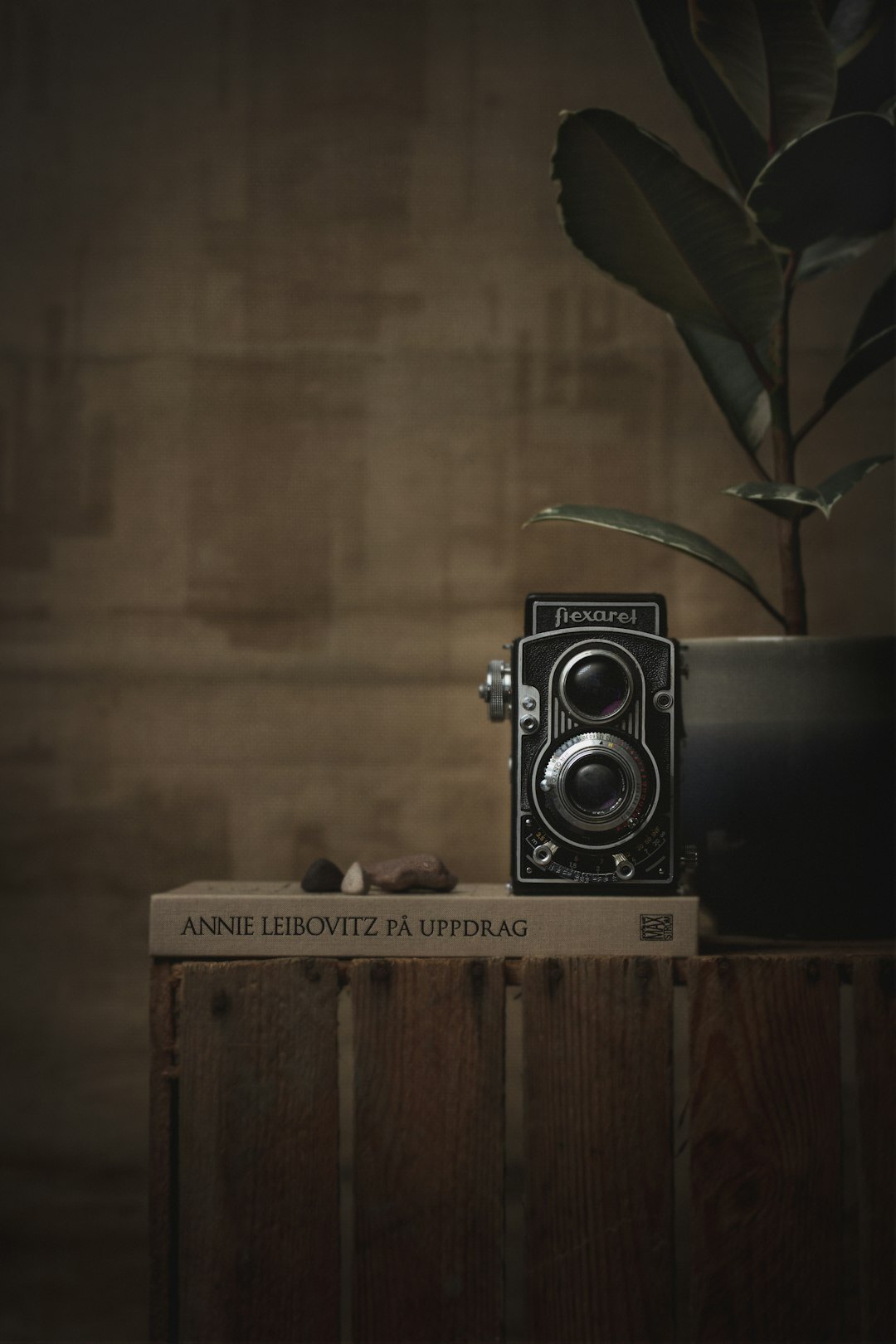 Antique brass camera and leather notebook on velvet surface
