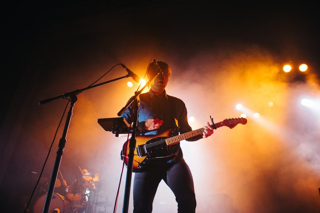 musician playing guitar on stage